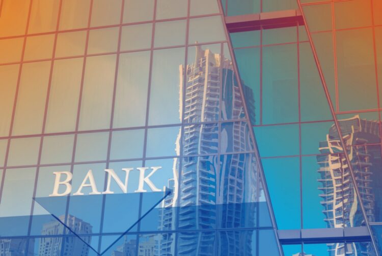 Gebouw met reflecterende ramen en het woord “bank” op de gevel